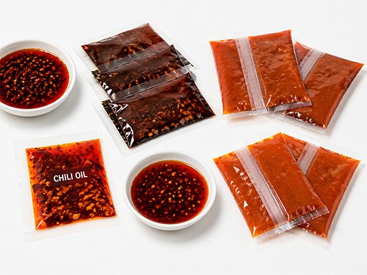Instant noodle seasoning oil sachets with chili and spice particles
